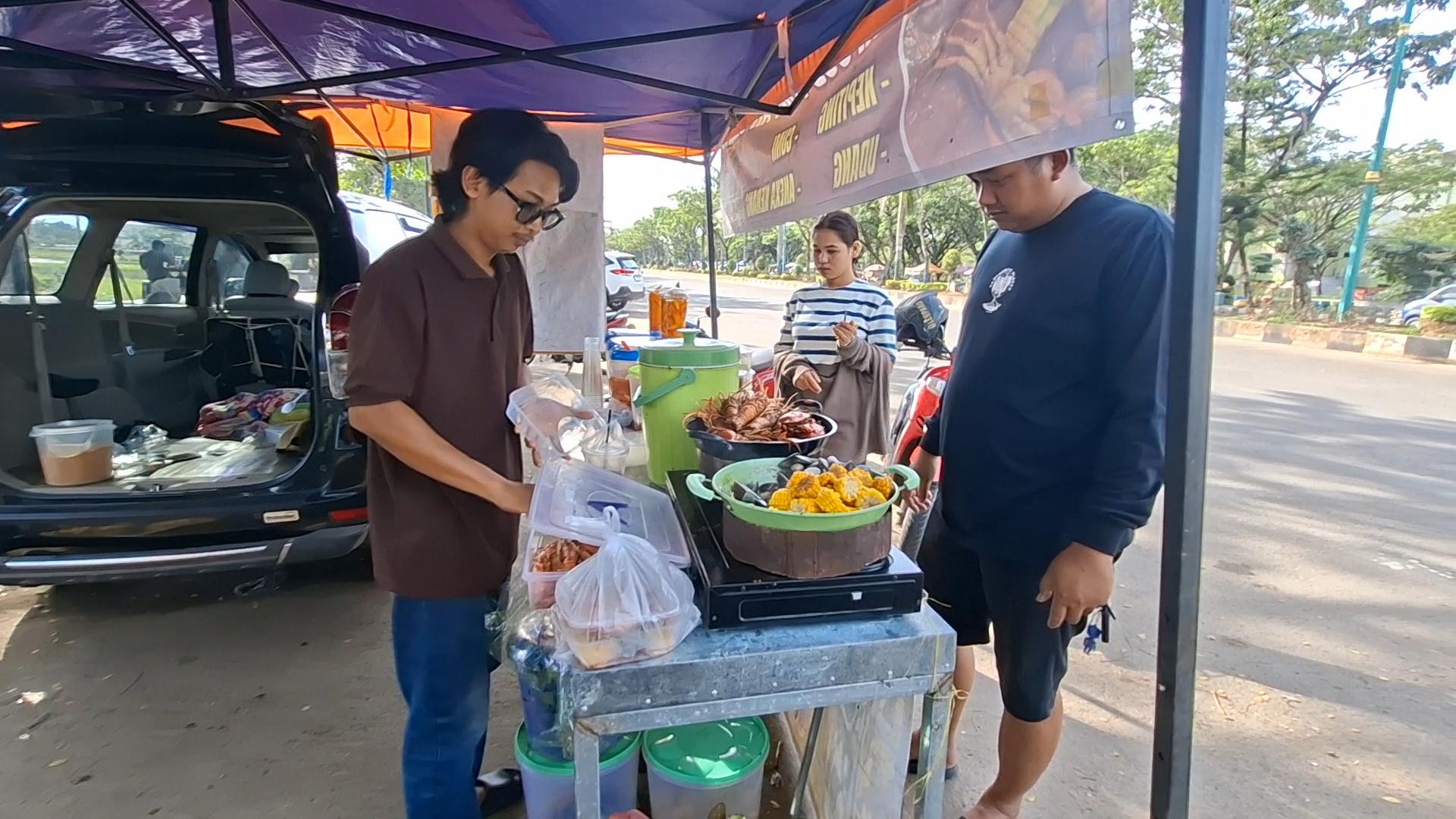 Didi-Kurniawan-melayani-pembeli-di-stand-Seafood-Tumpah-Siring-di-kawasan-Rantau-Baru.jpg
