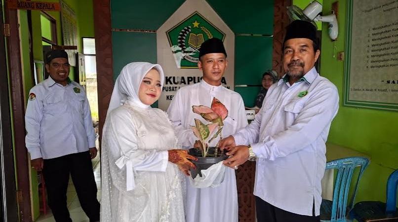 Kepala-KUA-Tapin-Utara-Sahmujid-Rahman-kanan-menerima-pot-bunga.jpg