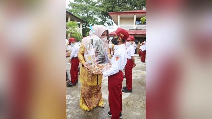 Ketua-GNOTA-Kabupaten-hss-Isnaniah-Achmad-Fikry-menyerahkan-bantuan-kepada-murid-SD.jpg