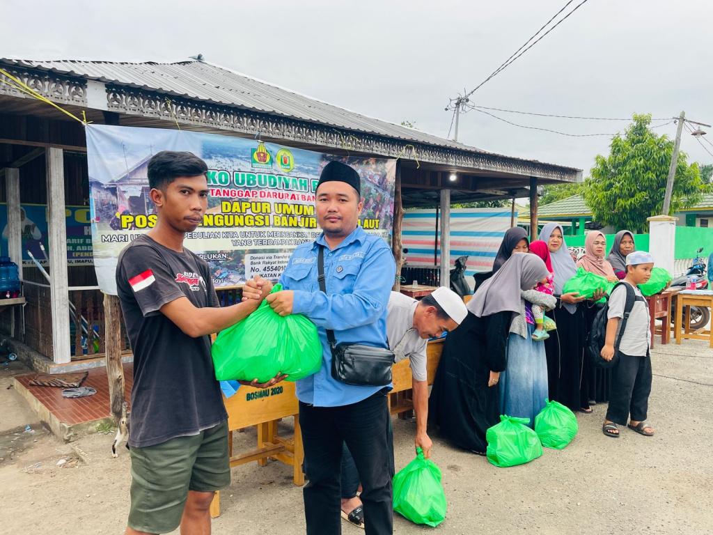 Koordinator-Posko-Peduli-Banjir-Ubudiyah-M-Habibi-menyerahkan-sembako.jpg