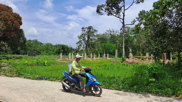 Seorang-petani-melintas-di-pembangunan-gerai-koperasi-merah-putih-di-Desa-Banua-Halat-Kanan.jpg