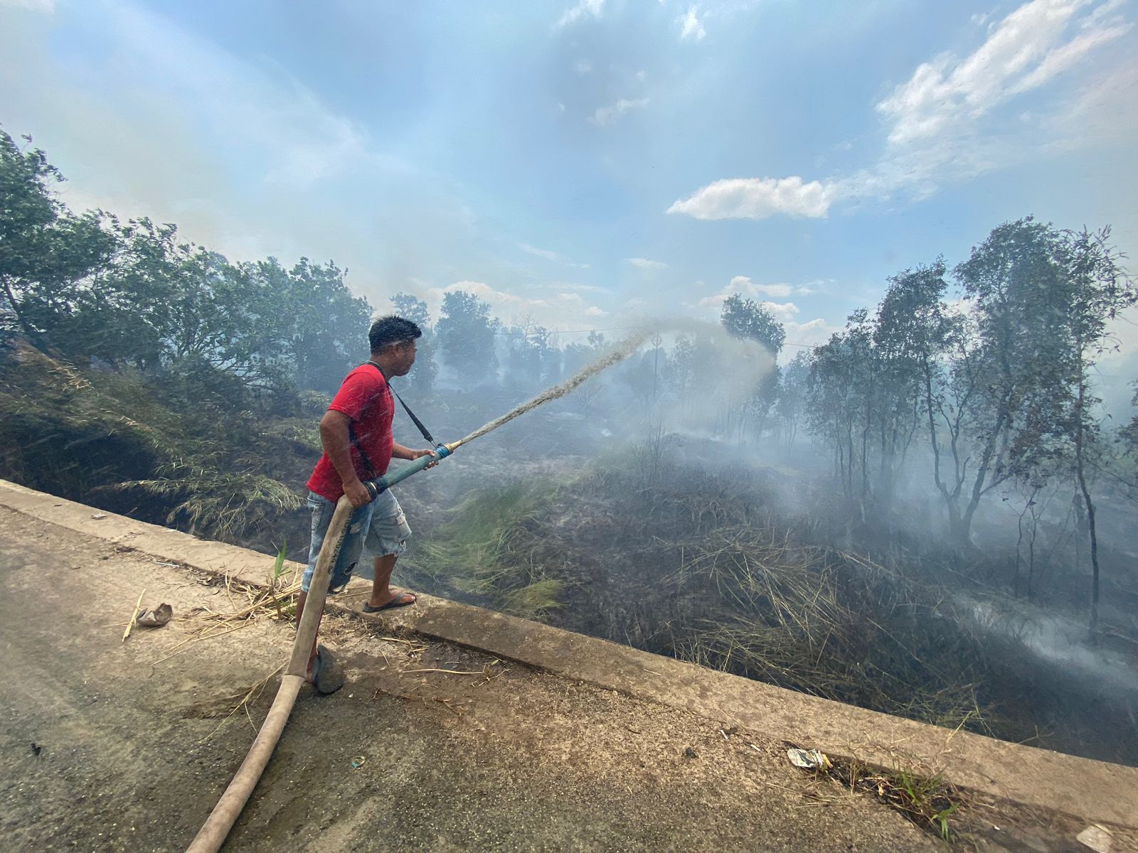 Seorang-relawan-berupaya-memadamkan-api-yang-membakar-lahan-di-kawasan-Jalan-Gubernur-Sarkawi1.jpg