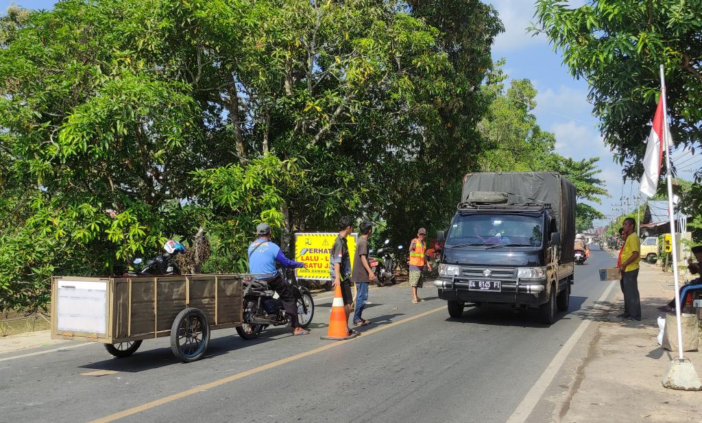 Warga-turut-membantu-mengatur-lalu-lintas-di-jalan-nasional-di-Desa-Turak-HSU.jpg