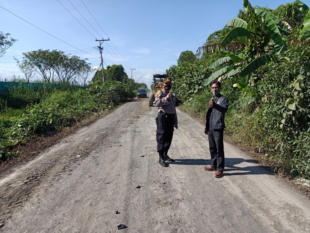 Anggota Polsek Kawal Perbaiki Jalan Nasional