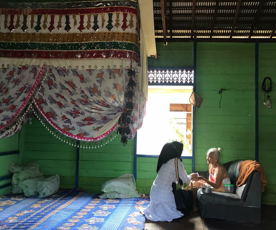 maryani-menyerahkan-bantuan-kepada-lansia-yang-memiliki-kelambu-khas-banjar.jpg