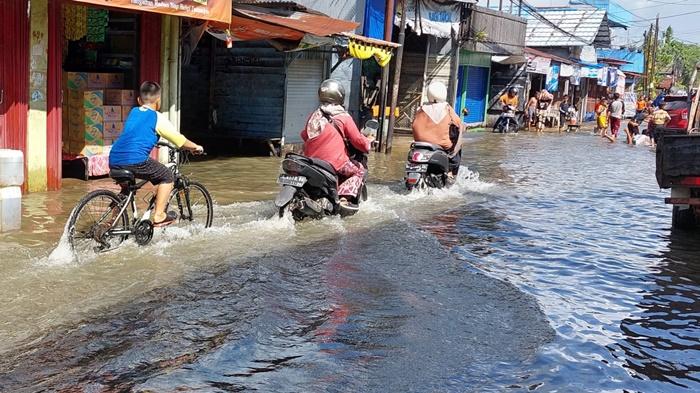 pengendara-sedang-melintasi-jalan-tergenang-di-Banjarmasin.jpg