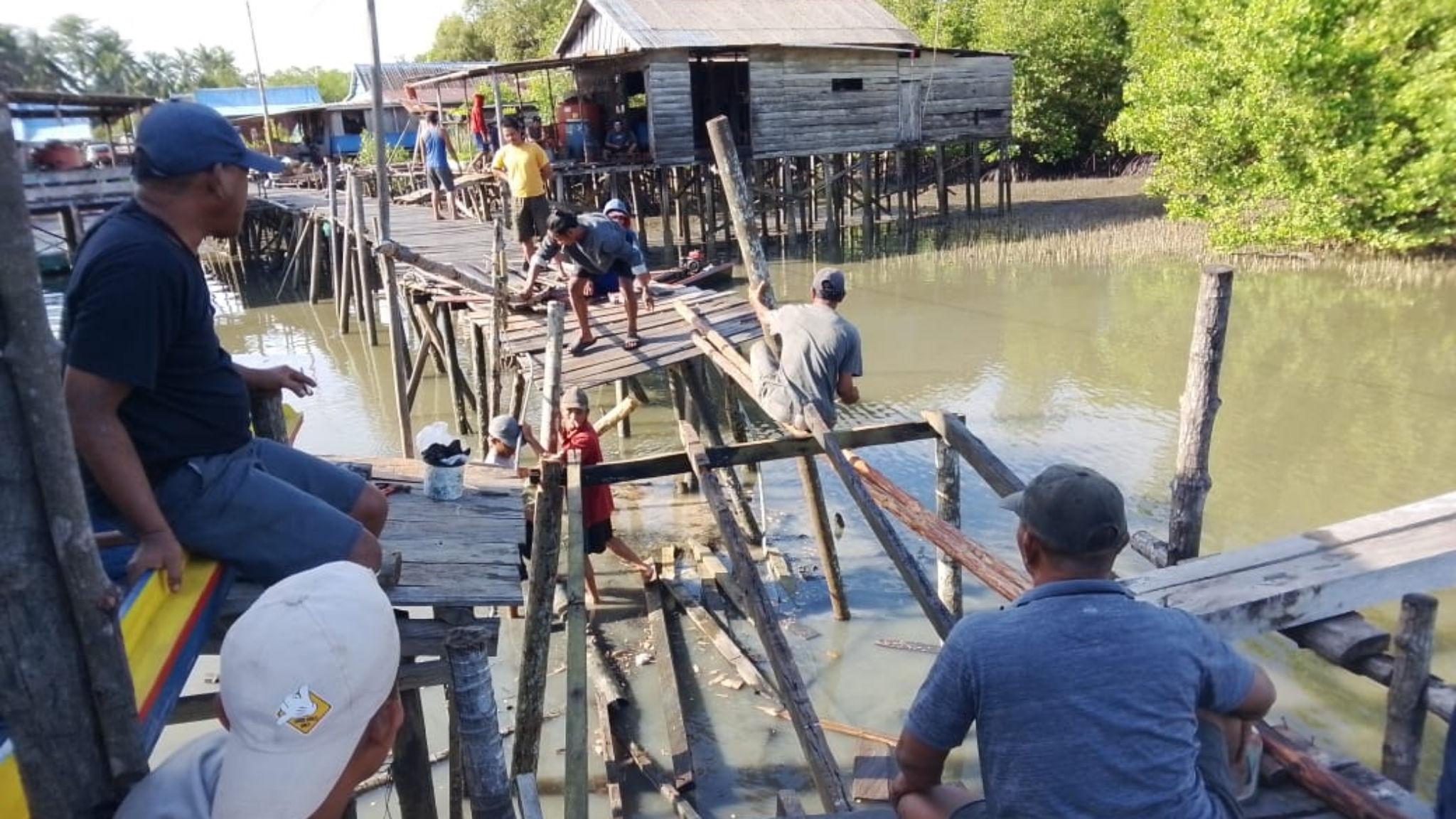warga-Rampa-Kapis-Desa-Batu-Tunau-gotong-royong-memperbaiki-jembatan-titian-yang-kembali-rusak.jpg