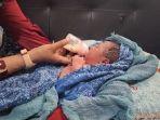 Bayi-yang-diterima-oleh-pedagang-kue-dari-Pasutri-asdfsdf.jpg