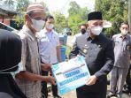 Bupati-H-Achmad-Fikry-menyerahkan-bantuan-kepada-korban-musibah-kebakaran-di-Desa-Baluti.jpg
