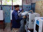 Calon-Bupati-Batola-Nomor-Urut-3-Mujiyat-dan-istri-menyalurkan-hak-suara-di-TPS-08.jpg