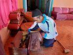Karnu-mengecek-perlengkapan-gamelan-di-kediamannya.jpg