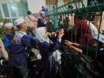 Keluarga-jamaah-haji-menyambut-kedatangan-kerabat-mereka-dari-balik-pagar-Asrama-Haji.jpg