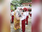 Ketua-GNOTA-Kabupaten-hss-Isnaniah-Achmad-Fikry-menyerahkan-bantuan-kepada-murid-SD.jpg