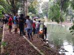 MAYAT-Petugas-bersama-relawan-mengevakuasi-mayat-yang-ditemukan-di-Taman-Mina-Tirta.jpg