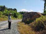 Muhammad-Rafii-berdiri-di-dekat-batu-besar-di-tepi-jalan-poros-Desa-Guntungbesar.jpg