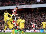Pemain-Arsenal-berebut-dengan-pemain-belakang-lawan-menyundul-bola-dalam-suatu-laga.jpg