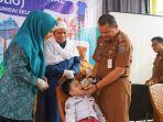 Pj-Bupati-HSS-memberikan-dua-tetas-vaksin-polio-didampingi-Pj-Ketua-TP-PKK-dan-Ketua-MUI.jpg