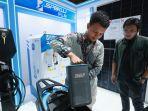 Salah-satu-pengunjung-IIMS-2025-antusias-melihat-simulasi-penukaran-baterai-motor-listrik.jpg