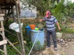 Supiani-mengambil-air-dari-tong-air-cadangannya.jpg