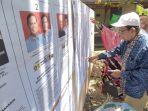 Warga-memeriksa-papan-informasi-di-depan-TPS-Kelurahan-Rantau-Kanan-10.jpg
