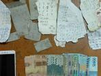 barang-bukti-uang-handphone-serta-17-lembar-kertas-bekas-sobekan.jpg