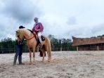 donyusman-pengunjung-saat-berada-di-atas-kuda-di-wisata-al-qarni-stable.jpg