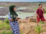dua-warga-berlatar-belakang-lubang-tambang-batu-bara-di-desa-banjarsari-kabupaten-tanbu.jpg