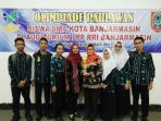 guru-dan-siswa-sman-11-memperlihatkan-piala-lomba-olimpiade-2016_20170219_185134.jpg