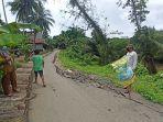 kepala-desa-tarangan-suriani-memperlihatkan-jalan-rusak.jpg