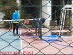 para-pekerja-membersihkan-lapangan-tenis-di-darma-praja.jpg