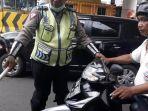 pengendara-sepeda-motor-dihentikan-polisi-karena-merokok_wm.jpg