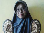 pengrajin-sandal-eceng-gondok-titik-endarwati-menunjukkan-hasil-kerajinannya.jpg