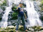 pengunjung-berpose-dengan-latar-belakang-air-terjun-bajuin-kabupaten-tala.jpg