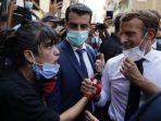 presiden-perancis-emmanuel-macron-mendengarkan-seorang-penduduk-saat-dia-mengunjungi.jpg