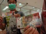 sejumlah-warga-menunjukkan-uang-baru-pecahan-rp-75000-saat-penukaran-uang.jpg