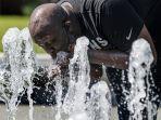 seorang-pria-minum-dari-air-mancur-saat-gelombang-panas-melanda.jpg