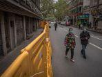 warga-berjalan-memakai-masker-di-jalanan-yang-masih-dipasang-pagar-pembatas-di-wuhan.jpg