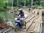 warga-desa-kambiyain-melewati-jembatan-darurat-sementara-pasca-putusnya-jembatan-gantung.jpg