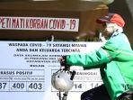 warga-melintas-di-dekat-replika-peti-mati-dan-papan-imbauan-waspada-covid-19.jpg