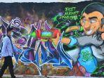 warga-melintas-di-depan-mural-bertuliskan-fight-against-corona.jpg