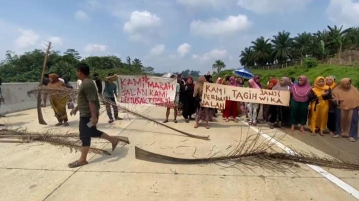 BLOKADE JALAN - Puluhan warga Kampung Citomo dan Cimerak, Desa Margamulya, Kacamata Cileles, Kabupaten Lebak, memblokade akses pembangunan Jalan Tol Serang-Panimbang, Selasa (23/9/2025).