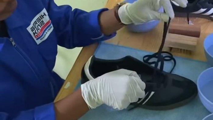 Tim Bersihkanz yang sedang memasang tali Sepatu konsumen.