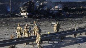 tentara-ukraina-berjalan-melewati-puing-puing-truk-militer.jpg