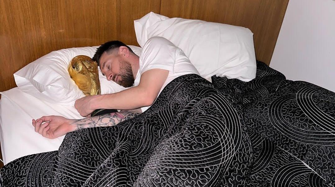 Foto-Lionel-Messi-sedang-tidur-di-atas-kasur-dengan-trofi-Piala-Dunia.jpg