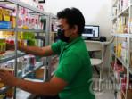 Petugas-merapikan-obat-sirop-di-etalase-salah-satu-apotek.jpg