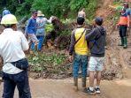 material-longsor-yang-menutupi-jalan-saat-dibersihkan-oleh-warga-di-kecamatan-cibeber-lebak.jpg