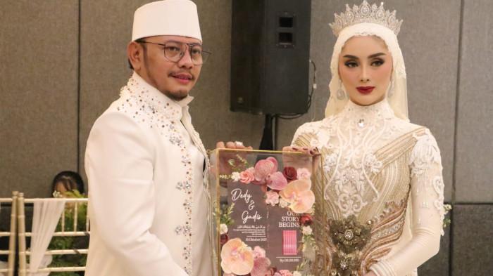 SAH SUAMI ISTRI - Wali Kota Tegal Dedy Yon Supriyono dan Gadis Sephi Febriana menunjukkan mas kawin seusai akad di Hotel Grand Mercure Solo Baru, Sukoharjo, Jumat (10/10/2025).