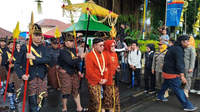 KIRAB PUSAKA - Bupati Banyumas Sadewo Tri Lastiono dan istri mengikuti kirab pusaka dalam rangkaian Hari Jadi Ke-455 Kabupaten Banyumas, Minggu (15/2/2026). Rombongan berangkat dari Rumah Dinas Wakil Bupati Banyumas menuju Pendopo Si Panji Purwokerto.