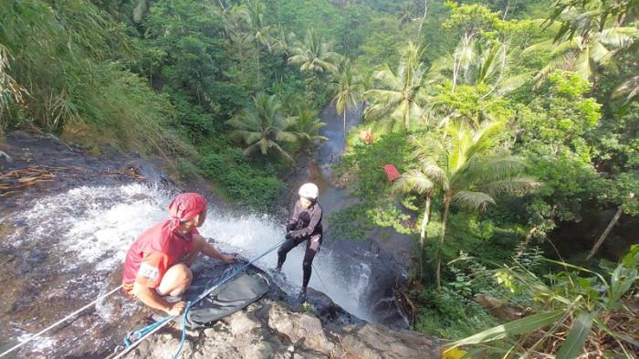 MENURUNI TEBING - Pengunjung asal Yogyakarta, Veri (29), menuruni tebing dengan teknik rappelling di Curug Silancur yang terletak di Desa Wadasmalang, Kecamatan Karangsambung, Kabupaten Kebumen, Minggu (17/5/2026). Wisata pemacu adrenalin canyoneering di Curug Silancur tengah digandrungi wisatawan.