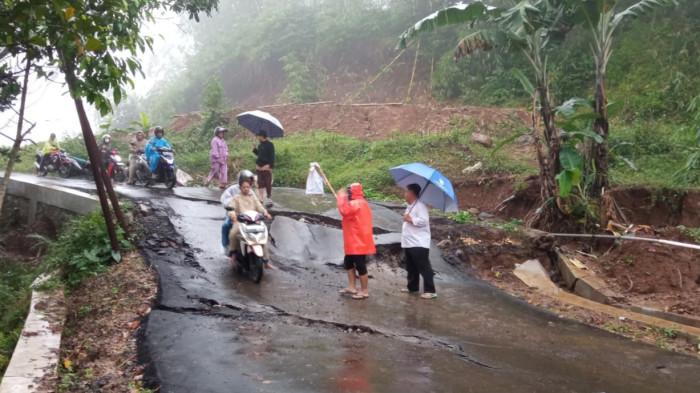 AMBLES - Jalan di Danasari, Kecamatan Bojong, Kabupaten Tegal, Jawa Tengah, ambles sedalam hingga 1 meter, Kamis (22/1/2026). Kejadian ini diduga dipicu hujan deras yang terjadi sejak Senin (19/1/2026) sampai Rabu (21/1/2026).